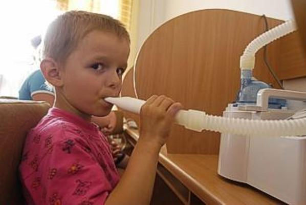 Ребенок пользуется небулайзером Ребенок пользуется небулайзером